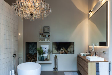 Großes Modernes Badezimmer En Suite mit flächenbündigen Schrankfronten, hellen Holzschränken, freistehender Badewanne, bodengleicher Dusche, Wandtoilette, weißen Fliesen, Kalkfliesen, beiger Wandfarbe, Keramikboden, Einbauwaschbecken, Mineralwerkstoff-Waschtisch, grauem Boden, offener Dusche und brauner Waschtischplatte in Hamburg