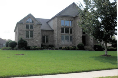 Mid-sized elegant gray two-story brick exterior home photo in Other