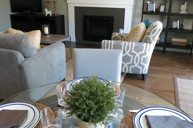 Example of a transitional open concept light wood floor family room design in Portland with green walls, a standard fireplace, a tile fireplace and a tv stand