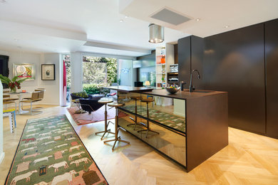 Photo of a mid-sized contemporary open plan kitchen in Sydney with an undermount sink, flat-panel cabinets, brown cabinets, quartz benchtops, stainless steel appliances, medium hardwood floors, multiple islands and beige floor.