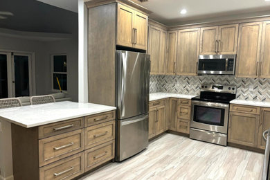 Inspiration for a mid-sized transitional u-shaped vinyl floor and beige floor eat-in kitchen remodel in Miami with an undermount sink, shaker cabinets, brown cabinets, quartz countertops, multicolored backsplash, mosaic tile backsplash, stainless steel appliances, a peninsula and white countertops