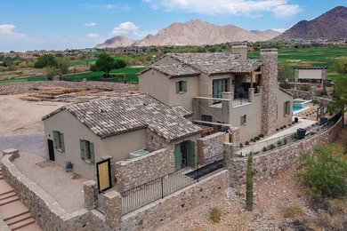 Inspiration for a mid-sized mediterranean brown two-story stucco exterior home remodel in Phoenix with a tile roof
