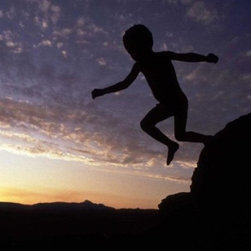 'A young bushman child leaps off a rock in Kaga Kama' by Chris Steele-Perkins - Photographs