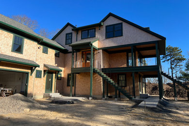 Foto de fachada de casa verde y gris de tres plantas con revestimiento de madera, tejado a dos aguas, tejado de teja de madera y teja