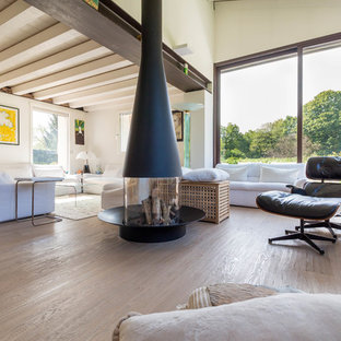 Idéer för ett stort modernt allrum med öppen planlösning, med vita väggar, ljust trägolv, en dubbelsidig öppen spis, en spiselkrans i metall och beiget golv