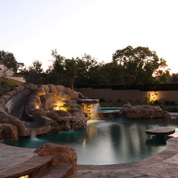 Backyard porch and pool with waterfall and slide.