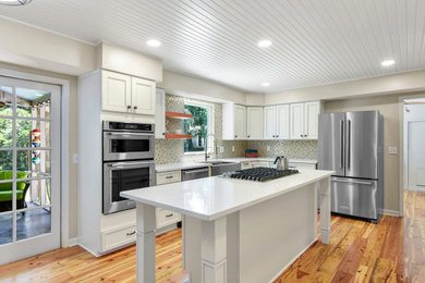 Example of a classic shiplap ceiling kitchen design in Jacksonville with multicolored backsplash, stainless steel appliances, an island and white countertops