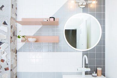 Tub/shower combo - mid-sized 1960s 3/4 gray tile and ceramic tile ceramic tile and white floor tub/shower combo idea in Detroit with open cabinets, an undermount tub, a one-piece toilet, gray walls, a wall-mount sink and a hinged shower door