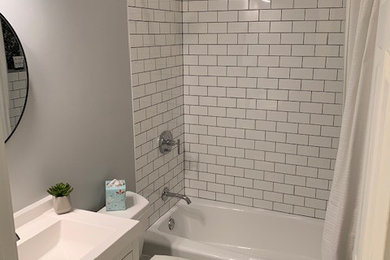 Ejemplo de cuarto de baño contemporáneo pequeño con armarios con paneles lisos, puertas de armario blancas, baldosas y/o azulejos blancos, aseo y ducha, encimera de acrílico y encimeras blancas