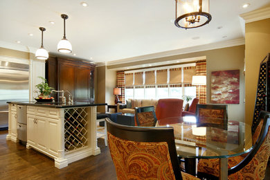 Eat-in kitchen - mid-sized transitional galley medium tone wood floor eat-in kitchen idea in Toronto with raised-panel cabinets, beige cabinets, granite countertops, beige backsplash, stone tile backsplash, an island and stainless steel appliances