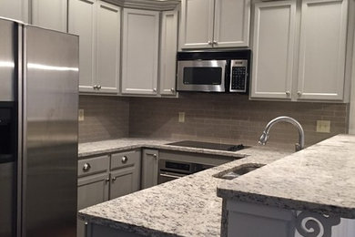 Inspiration for a timeless ceramic tile and brown floor kitchen remodel in Other with recessed-panel cabinets, gray cabinets and granite countertops