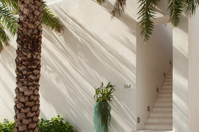 Inspiration for a mid-sized modern white three-story stucco exterior home remodel in Other with a metal roof