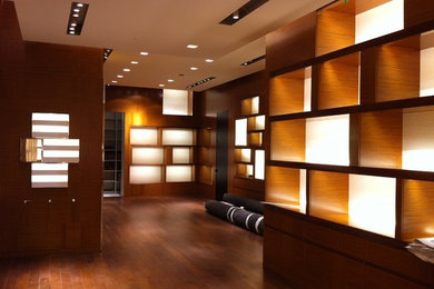 Example of a small trendy gender-neutral medium tone wood floor reach-in closet design in Toronto with flat-panel cabinets and light wood cabinets