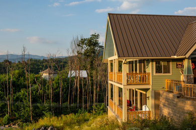 Inspiration for a mid-sized rustic green three-story concrete fiberboard exterior home remodel in Other with a metal roof