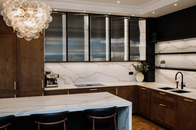 Design ideas for a large contemporary l-shaped kitchen/diner in Other with recessed-panel cabinets, dark wood cabinets, quartz worktops, engineered quartz splashback, black appliances and an island.
