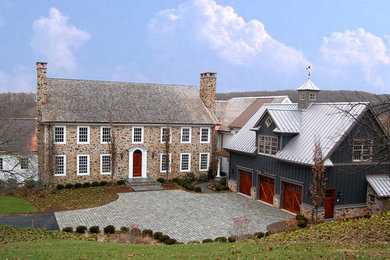 Large traditional gray two-story brick exterior home idea in New York
