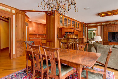 Example of a large arts and crafts light wood floor and white floor enclosed dining room design in Cleveland with a standard fireplace and a stone fireplace