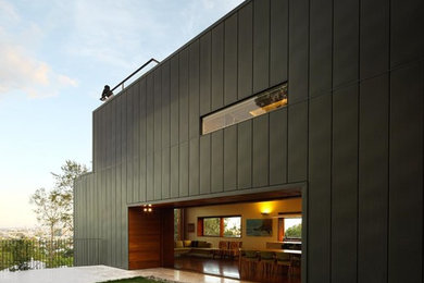 Photo of an expansive contemporary grey exterior in Brisbane with metal siding and a flat roof.