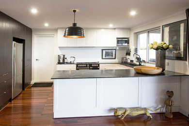 This is an example of a large eclectic u-shaped open plan kitchen in Perth with subway tile splashback, dark hardwood floors, a drop-in sink, shaker cabinets, white cabinets, quartzite benchtops, white splashback and no island.