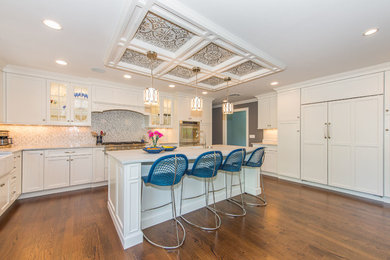 Inspiration for a large transitional u-shaped dark wood floor and brown floor eat-in kitchen remodel in New York with recessed-panel cabinets, white cabinets, marble countertops, stone tile backsplash, an island, a farmhouse sink, paneled appliances, gray backsplash and white countertops