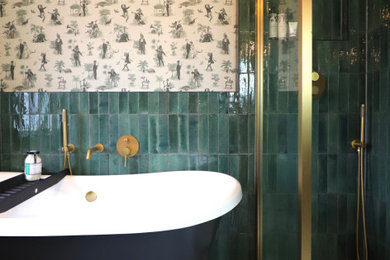 Photo of a medium sized eclectic ensuite bathroom in Other with open cabinets, white cabinets, a freestanding bath, a walk-in shower, a one-piece toilet, green tiles, metro tiles, green walls, porcelain flooring, an integrated sink, glass worktops, green floors, an open shower, white worktops, a wall niche, a single sink, a freestanding vanity unit and wallpapered walls.
