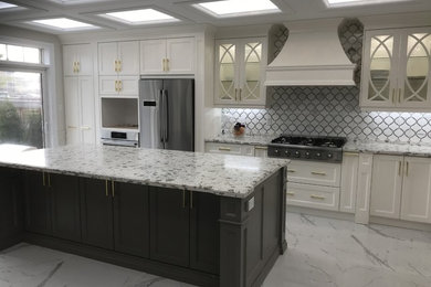 Large transitional single-wall marble floor and gray floor kitchen photo in Toronto with recessed-panel cabinets, white cabinets, granite countertops, gray backsplash, marble backsplash, stainless steel appliances, an island and gray countertops