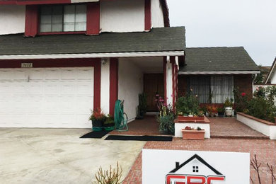 Example of a classic white two-story house exterior design in San Diego with a tile roof