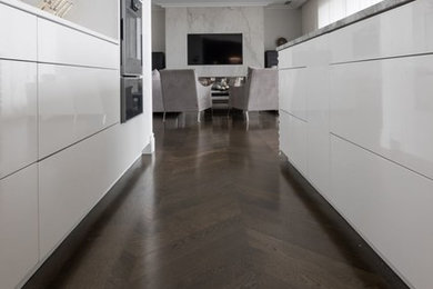 Contemporary kitchen in Auckland with light hardwood floors and brown floor.