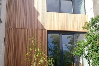 Design ideas for a contemporary exterior in Brussels with wood siding and a flat roof.