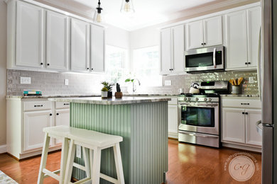 Eat-in kitchen - mid-sized transitional u-shaped medium tone wood floor and brown floor eat-in kitchen idea in Richmond with an undermount sink, raised-panel cabinets, white cabinets, marble countertops, brown backsplash, porcelain backsplash, stainless steel appliances and an island