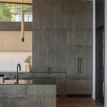 Full-height oak cabinetry with grain-matched panels, integrated refrigerator, an