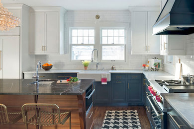 Design ideas for an eclectic l-shaped separate kitchen in Minneapolis with a farmhouse sink, flat-panel cabinets, grey cabinets, marble benchtops, white splashback, subway tile splashback, stainless steel appliances, medium hardwood floors, with island, brown floor and white benchtop.
