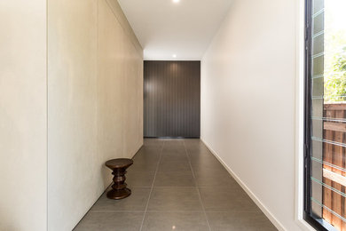 Photo of a mid-sized contemporary foyer in Brisbane with porcelain floors and brown floor.