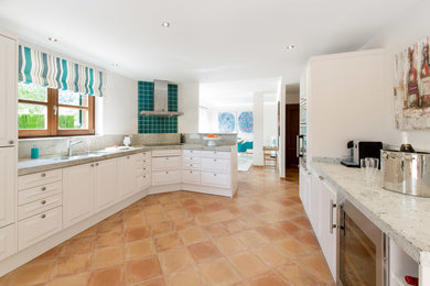 Large tuscan galley terra-cotta tile open concept kitchen photo in Other with recessed-panel cabinets, white cabinets, granite countertops, stainless steel appliances and no island
