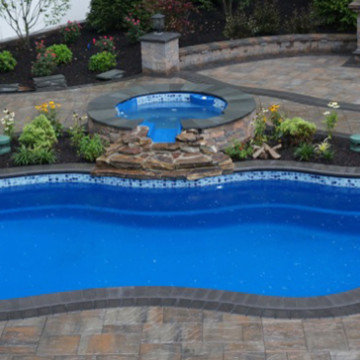 Fiberglass pool with spillover spa and custom pool deck hardscaping