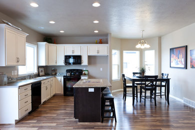 Mid-sized arts and crafts l-shaped laminate floor eat-in kitchen photo in Salt Lake City with a double-bowl sink, recessed-panel cabinets, white cabinets, granite countertops, gray backsplash, black appliances and an island