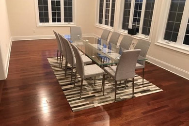 Example of a large trendy medium tone wood floor enclosed dining room design in Philadelphia with beige walls and no fireplace