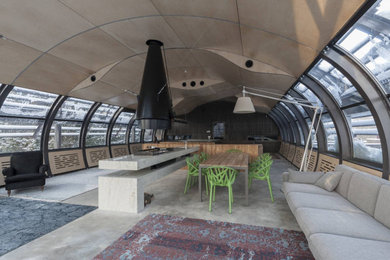 Foto de galería actual grande con suelo de cemento, chimeneas suspendidas, marco de chimenea de metal, techo de vidrio y suelo gris
