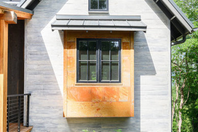 Example of a mountain style gray three-story mixed siding exterior home design in Other with a metal roof