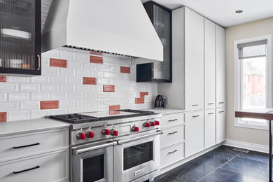 Contemporary single-wall kitchen in Ottawa with recessed-panel cabinets, white cabinets, multi-coloured splashback, stainless steel appliances, no island, black floor and white benchtop.