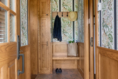 Inspiration for a small timeless brown floor, wainscoting and wallpaper entry hall remodel in Minneapolis with multicolored walls
