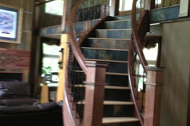 Mid-sized wooden curved staircase photo in Little Rock with tile risers