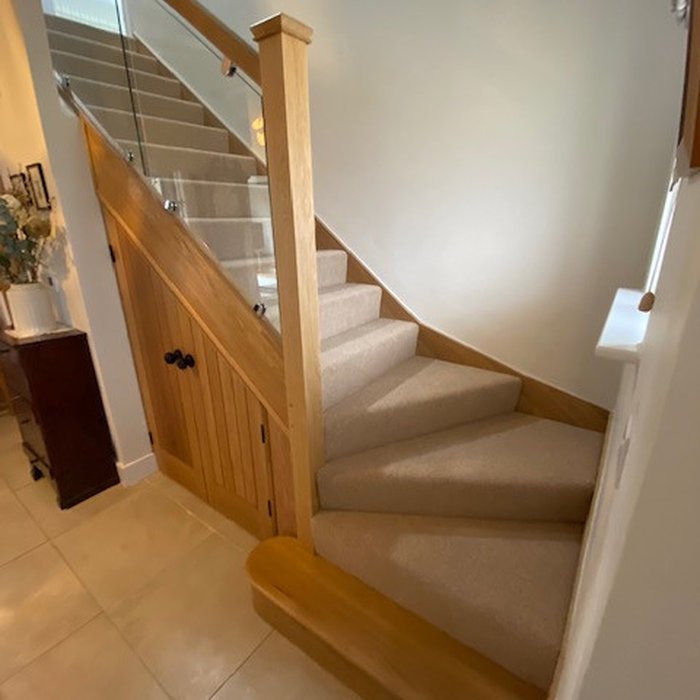 Inspiration for a medium sized contemporary wood l-shaped glass railing staircase in Hampshire with wood risers and brick walls.