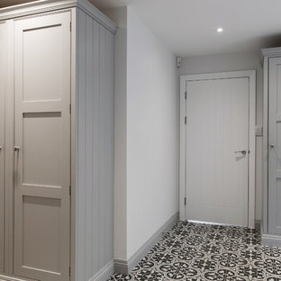 Photo of an expansive contemporary u-shaped utility room in Kent with shaker cabinets, grey cabinets, ceramic flooring, a side by side washer and dryer, a single-bowl sink, laminate countertops, grey walls, yellow floors and grey worktops.