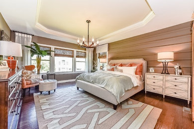 Inspiration for a mid-sized transitional master medium tone wood floor bedroom remodel in Charlotte with brown walls and no fireplace