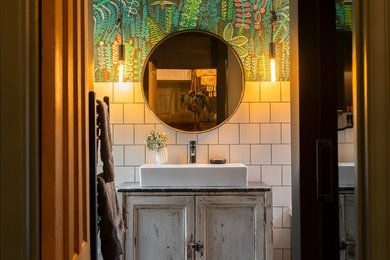 This is an example of a medium sized bohemian family bathroom in Other with a japanese bath, a built-in shower, a bidet, black and white tiles, cement tiles, cement flooring, a trough sink, marble worktops, a hinged door, a feature wall, a single sink, a freestanding vanity unit and wallpapered walls.