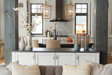 Transitional l-shaped medium tone wood floor and brown floor open concept kitchen photo in Other with an undermount sink, recessed-panel cabinets, white cabinets, quartz countertops, gray backsplash, marble backsplash, black appliances, an island and white countertops