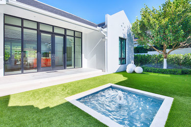 Mid-sized contemporary white one-story stucco exterior home idea in Orlando with a shingle roof