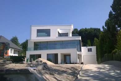 Mittelgroßes, Dreistöckiges Mediterranes Haus mit Putzfassade, weißer Fassadenfarbe und Flachdach in Stuttgart