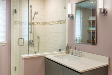 Inspiration for a mid-sized transitional 3/4 bathroom in Boston with flat-panel cabinets, a corner shower, ceramic tile, pink walls, porcelain floors, an integrated sink, solid surface benchtops, grey cabinets and beige tile.